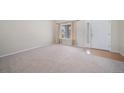Bright living room with neutral carpet, beige walls, and a large window, offering a welcoming space at 5178 Netherland St, Denver, CO 80249