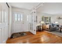 Bright foyer featuring hardwood floors, a glass-paneled front door, and an open view to the living room at 7521 S Race St, Centennial, CO 80122