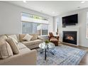 Cozy living room featuring a fireplace, comfortable seating, and large window at 1568 Wolff St, Denver, CO 80204