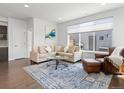 Bright living room featuring hardwood floors, a modern sofa, and a large window at 1568 Wolff St, Denver, CO 80204
