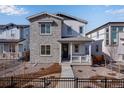 Inviting two-story home featuring stone accents, a covered porch, and professional landscaping at 3324 N Haleyville Ct, Aurora, CO 80019