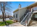 Exterior view of unit with black stair rail, sidewalk, grass, and a partial view of a car and bare tree at 4086 S Carson St # F, Aurora, CO 80014