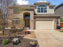Inviting front entrance with a brick facade, arched doorway, and a well-maintained lawn at 7869 Solstice Way, Castle Rock, CO 80108