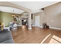 Open-concept living area with hardwood floors, archways, and a view of the staircase at 7869 Solstice Way, Castle Rock, CO 80108