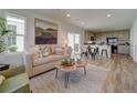 Bright, open-concept living area with a comfortable sofa, unique wood coffee table, and access to a modern kitchen at 10366 Uvalda Ct, Commerce City, CO 80022