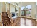 Spacious living room with fireplace, large windows, and hardwood floors with a staircase at 23029 Cleveland Dr, Parker, CO 80138