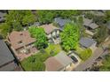 Aerial view showcases a home's expansive backyard, mature trees, complemented by surrounding neighborhood, detached garage, and patio at 2236 Forest St, Denver, CO 80207