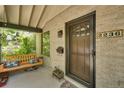 Inviting front porch featuring a charming swing, brick accents, and a stylish front door with the house number displayed at 2236 Forest St, Denver, CO 80207