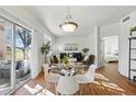 Open-concept dining area with modern table set, next to a living room with a sliding door to a patio at 12924 Ironstone Way # 103, Parker, CO 80134
