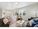 Bright and airy living room featuring modern decor, wood floors, and large windows at 12924 Ironstone Way # 103, Parker, CO 80134