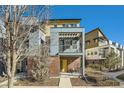 Contemporary three-story townhouse featuring a private balcony and a bright yellow front door at 11225 Colony Cir, Broomfield, CO 80021