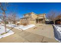 Two-story house with brick and siding, two-car garage, and covered porch at 3012 S Jericho Way, Aurora, CO 80013