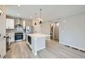 Modern kitchen with white cabinets, stainless steel appliances, and a spacious center island at 6906 Kendrick Ln, Arvada, CO 80007
