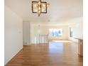 Bright living space showcasing hardwood floors, modern light fixtures, and a large window with scenic views at 1411 S Welch Cir, Lakewood, CO 80228