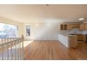 Spacious living room featuring hardwood floors, neutral paint, and large windows offering plenty of natural light at 1411 S Welch Cir, Lakewood, CO 80228