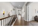 Bright hallway showcasing hardwood floors, decorative lighting, and elegant iron railing at 671 Hiddenbrook Ct, Littleton, CO 80126