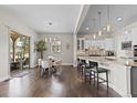 Open-concept kitchen featuring a breakfast bar, pendant lighting, and access to the outdoor patio at 671 Hiddenbrook Ct, Littleton, CO 80126