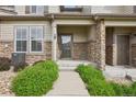 Inviting townhouse entrance with stone columns, and lush green bushes on each side of the walkway at 17032 Blue Mist Grv, Monument, CO 80132
