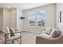Cozy living room features two large windows, modern furnishings, and wood flooring at 17032 Blue Mist Grv, Monument, CO 80132
