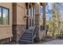 Inviting front entrance with stone accents, elegant lighting, and a well-maintained walkway at 5699 Northwood Dr, Evergreen, CO 80439