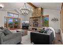 Stunning living room featuring a fireplace, vaulted ceilings, and natural light at 5699 Northwood Dr, Evergreen, CO 80439