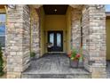 Close-up of the front door, showcasing the stone pillars and manicured flower pots at 634 County Road 37, Brighton, CO 80603