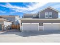 Townhome exterior view showing a two-car garage with light gray paint and a blue sky backdrop at 11442 Booth Falls Ct, Parker, CO 80134
