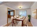 Elegant dining room with modern light fixture, large window, and seating for six around a wooden table at 4580 Balsam St, Wheat Ridge, CO 80033