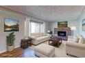 Bright living room features a brick fireplace, hardwood floors, and large windows for ample natural light at 4580 Balsam St, Wheat Ridge, CO 80033