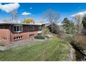 Expansive backyard with lush green lawn and mature trees, offering a serene and private outdoor space at 7000 Highland Dr, Lakewood, CO 80214