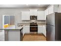 Bright kitchen featuring stainless steel appliances, granite countertops, and ample cabinet space at 7208 Dolores Ave, Frederick, CO 80530