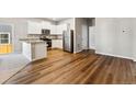 Open-concept kitchen with stainless steel appliances, granite countertops and wood flooring at 7208 Dolores Ave, Frederick, CO 80530