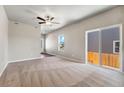 Spacious living room with plush carpeting, ceiling fan, and sliding glass doors to the backyard at 7208 Dolores Ave, Frederick, CO 80530