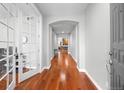 Inviting hallway featuring gleaming hardwood floors and an elegant arched doorway leading to the living area at 8555 W Quarles Pl, Littleton, CO 80128