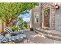 Inviting front porch with stylish lounge chairs, steps to the front door and manicured landscaping at 10837 Fox Sedge Way, Highlands Ranch, CO 80126