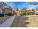 Charming two-story home with a walkway leading to a red front door and a well-manicured lawn at 3883 S Elm St, Denver, CO 80237