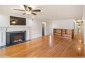 Spacious living room with a cozy fireplace, hardwood floors, and stylish built-in shelving at 7079 S Tamarac Ct, Centennial, CO 80112