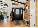 Inviting entryway with hardwood floors, coat rack, and wood-paneled accent wall at 1730 Ward Cir, Franktown, CO 80116