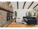 Cozy living room features a stone fireplace, wood beams, and hardwood floors at 1730 Ward Cir, Franktown, CO 80116