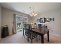 Dining room with a dark wood table, stylish chandelier, and sliding door to the outdoor space at 9800 Mayfair St # E, Englewood, CO 80112