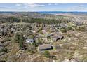 Wide aerial shot of houses nestled among trees and vegetation in a neighborhood with mountain views in the distance at 53 Taylor Ct, Castle Rock, CO 80104