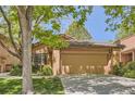 Two-car garage with a well-maintained lawn surrounded by mature trees on a sunny day at 7500 E Dartmouth Ave # 22, Denver, CO 80231