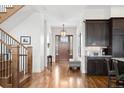 Bright foyer with hardwood floors, a staircase, and a glimpse of the front door and kitchen at 1644 S Lafayette St, Denver, CO 80210