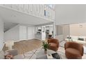 Bright living room featuring soaring ceilings, modern furniture, wood floors, and slider to a private patio at 13633 E Yale Ave # B, Aurora, CO 80015