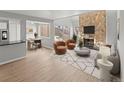 Living room featuring a stone fireplace, modern furniture, and an open layout to the dining area at 13633 E Yale Ave # B, Aurora, CO 80015