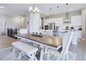 Open-concept dining area with a large wooden table and stylish seating at 12628 Bayshore St, Firestone, CO 80504