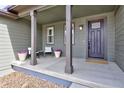 Inviting front porch with seating area and a stylish front door at 12628 Bayshore St, Firestone, CO 80504