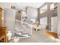 Spacious living room with soaring ceilings, bright windows and staircase to second level at 10633 Wynspire Way, Highlands Ranch, CO 80130