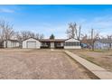 Single-story home with detached garage and stone driveway on a clear day, perfect for Gathering living at 11640 W 13Th Ave, Lakewood, CO 80401