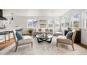 Bright living room with hardwood floors, neutral furnishings, a round glass coffee table, and large windows for natural light at 11640 W 13Th Ave, Lakewood, CO 80401